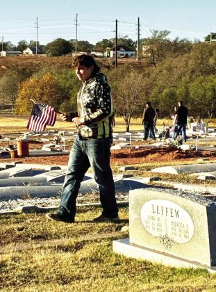 Memphis High School Family, Career and Community Leaders of America (FCCLA) and Future Farmers of America (FFA) members place American flags on the graves of veterans at Fairview Cemetery in Memphis. Memphis ISD