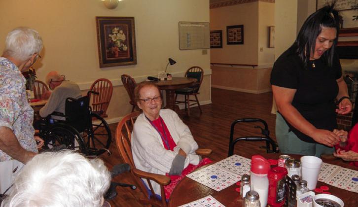 Linda Rothwell has her bingo cards ready for the next game at the weekly bingo session at Cottage Village Assisted Living Facility in Childress. At left, in the foreground, is Frances Weatherlee and Ann Simmers, a regular bingo-time visitor. At right is Cottage Village Caregiver Kimberly Ramos. The number of weekly games played depends on how many the residents request, said number caller Anne Fromm.