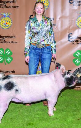 Maci Brewer shows the first-place Class 2 Cross Swine, purchased by Tommy Coleman at the Premium Sale.