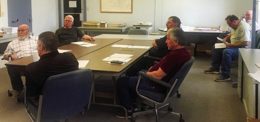 Wellington Councilman Brandon Ward, clockwise from left, Mayor Larry Adams, Councilmen Kenneth Warren, Brent Martin and Jimmy Cantu Jr. and visitors Clint Thomas and Cliff Waller listen as City Manager Jon Sessions gives his City Manager’s report. The Red River Sun/Bev Odom