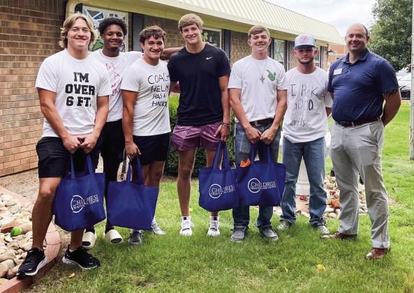 Childress Healthcare Center Administrator Joshua Sue, right, donates candy to Childress Bobcats, from left, Reid Felton, Lamont Nickleberry, Devin Edmondson, Seth Taylor, Custer Keys and Nick McMinn for the homecoming parade Wednesday, Aug. 31. Courtesy Photo