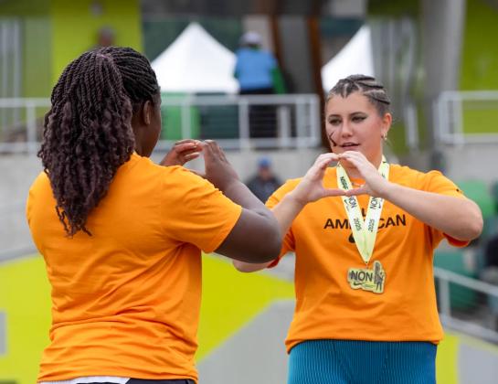 University of Oregon commit Taylor Wiseman practices flashing the “O” with University of Pennsylvania commit Jessica Oji before going on television for the discus awards during the Nike Outdoor Nationals at Hayward Field in Eugene, Ore. (The Register-Guard/Ben Lonergan)
