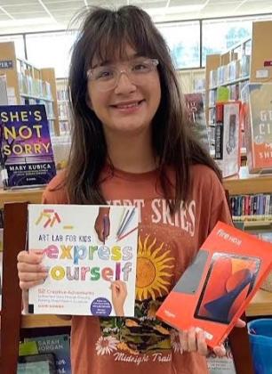 Wellington Junior High School eighth-grader Emma Zaragoza claims the teen Summer Reading Program prize, a brand-new Kindle Fire HD 8, to promote her love of reading even more.