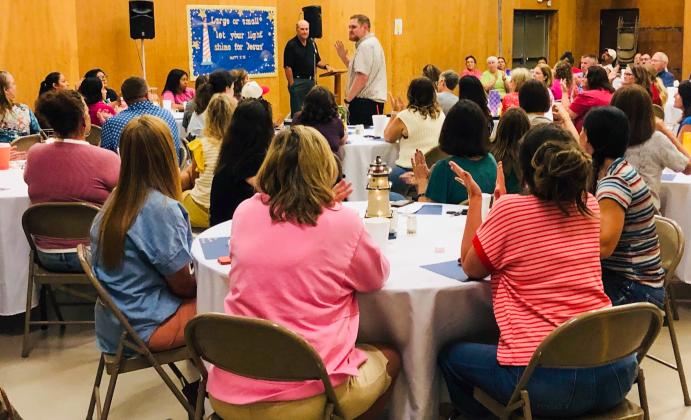 Matthew Newsom, new Rocket Regiment director, greets the crowd as Wellington Independent School District Superintendent Kurt Ashmore introduces new staff during the First Baptist Church Prayer Breakfast to open the 2025-2026 school year.
