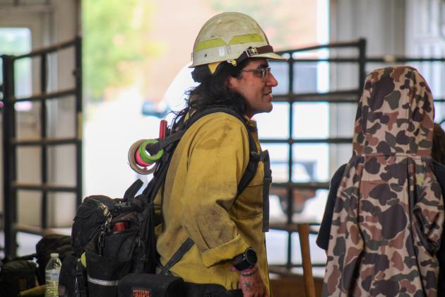 Texas A&amp;M Forest Service Fire Coordinator Gilberto Dominguez shows students typical wildland firefighter gear, including “yellows,” the flame-resistant bright, yellow safety shirts worn while fighting fires.
