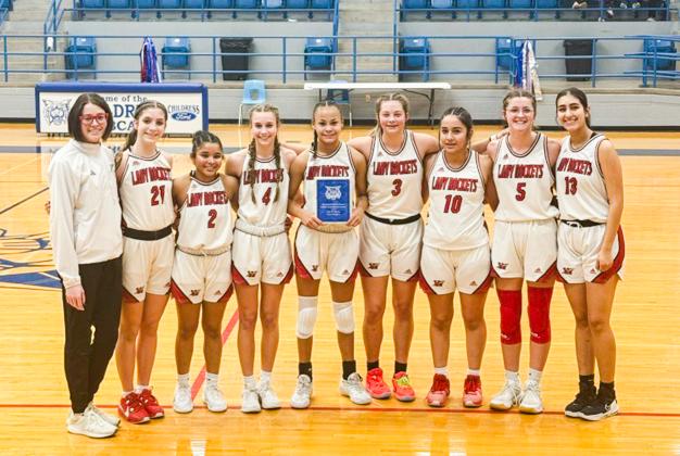 In the junior varsity division, the Wellington Lady Rockets secure the 4th Annual Childress Rotary Holiday Invitational Tournament Championship, taking a 39-26 win over Seymour. From left: Coach Courtney Head, Anna Henard, Demi Massey, Libby Chandler, Raelynn Castor, Maci Brewer, Hazel Estrada, Autumn Shatswell, Valerie Cruz.