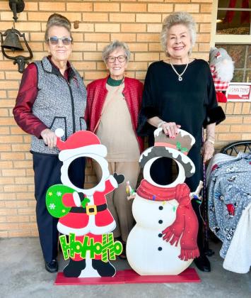 Hearts United Give Support (HUGS) volunteers Sharon Starkey, left, Fran Eigenmann and Vada Wood greet guests at the home of Rex and Amy Henard last Sunday afternoon during the Holiday Home Tour.