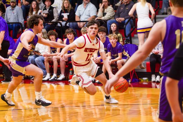 Wellington’s Jax Cantu evaluates opportunity, while Carson Kane (10) and Easton Wischkaemper (13) move into play position last Friday, Feb. 6 against Wheeler, securing a 68-51 win.