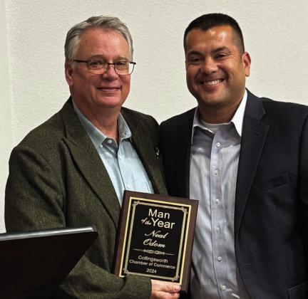 Man of the Year Neal Odom, left, accepts his award from Wellington High School Principal Jermaine Cantu.