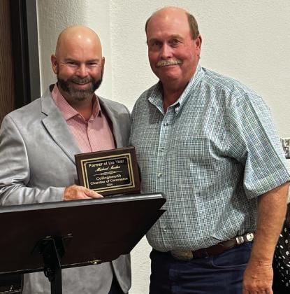 Farmer of the Year Michael Souder, right, accepts his honor from the 2023 Farmer of the Year, Rusty Strickland.