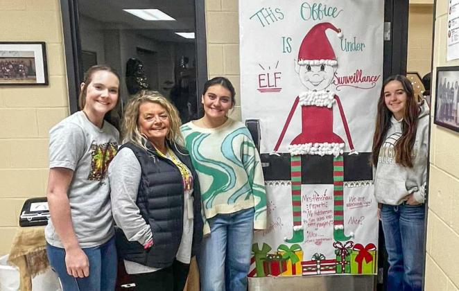 Memphis High School secretary LaDonna Henshaw accepts second place in the holiday door decorating contest with a door that reads, “This office is under elf surveillance.”