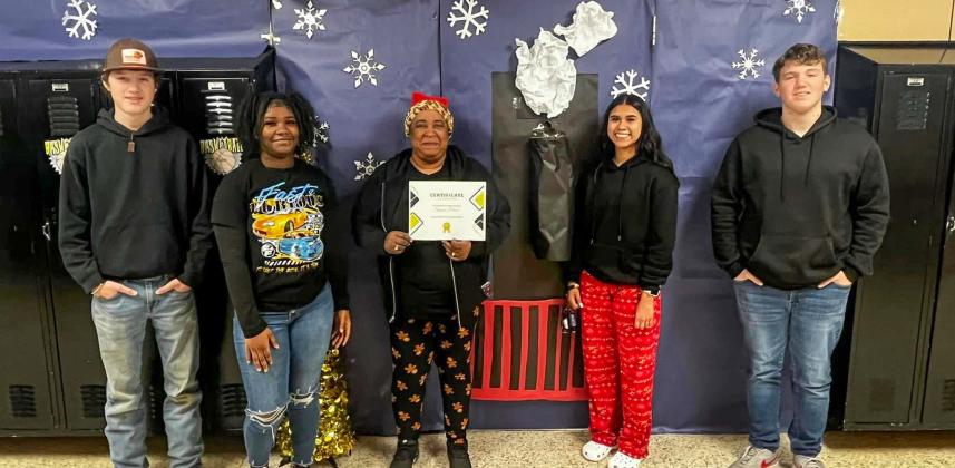 Memphis High School paraprofessional Sharon Hearn accepts third place in the recent holiday door decorating contest with a Polar Express-themed door.