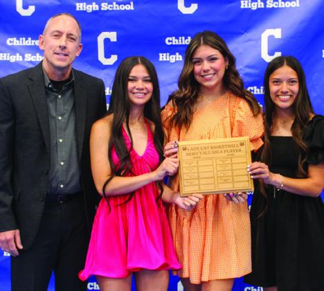 Girls’ basketball coach Steve Walker, left, awards Lady Cat Basketball Co-Offensive Most Valuable Players (MVPs) Kar’Leigh Husband, second from left, and Clarissa Gamboa, right, and Lady Cat Basketball Defensive MVP Journey Prince, second from right.
