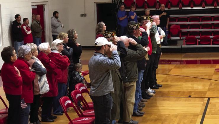 Veterans salute as they recite the Pledge of Allegiance.