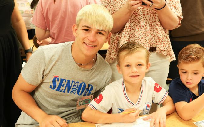 Kindergarteners, seniors team up for Kindergarten Signing Day