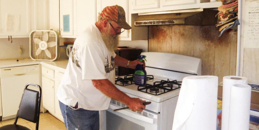 James Votaw checks the range at the Childress Senior Citizens Center following a report of a possible gas leak. The smell of gas recently occurred with the range as the possible source, Childress Senior Citizens Center Director Glenda Goundie said. Photo by Grace Holman