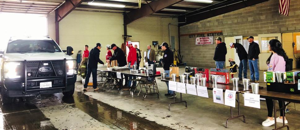 Members of Wellington Volunteer Fire Department conduct a “by donation only” drivethru brisket sandwich fundraiser for Sunday lunch. A long line of vehicles made their way through the fire station in the gentle rain.