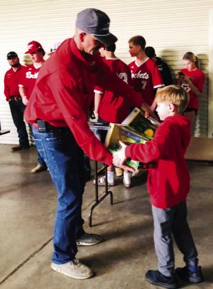 Wellington Fire Chief Sawyer Sims presents the John Deere collectible metal combine, tractor and toolbox, donated by Western Equipment, to ticket winner Stratton Wynn.