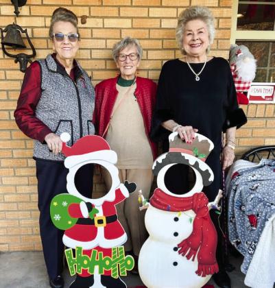 Hearts United Give Support (HUGS) volunteers Sharon Starkey, left, Fran Eigenmann and Vada Wood greet guests at the home of Rex and Amy Henard last Sunday afternoon during the Holiday Home Tour.