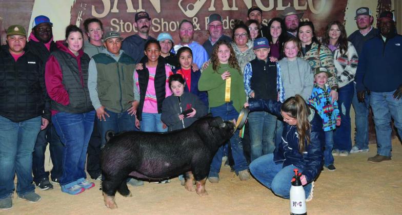 Wellington Elementary School fifth-grader Hadlee Patterson places fifth with her Poland gilt at the Tuesday, Feb. 11 San Angelo Stock Show and Rodeo. The daughter of John and Lauren Patterson, Hadlee is congratulated by her crew of supporters.