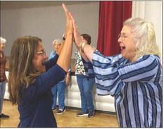 Karen Caldwell, left, and Vada Wood give each other a high five during the entertaining cornhole competition at the recent social hosted by Wellington Senior Citizens Center.