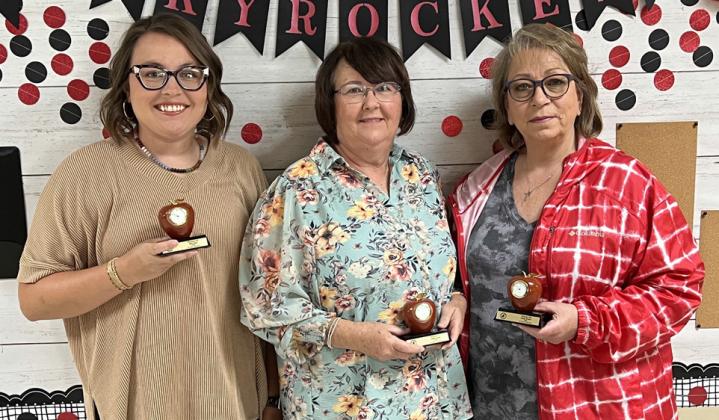 For 10 years of service to Wellington Independent School District, Rhae Jones, left, Debbie George and Kathy Brewer garner red apple clock mementoes. Not pictured: Jermaine Cantu.