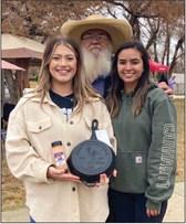 Wellington State Bank’s Alisha Weatherly and Britany Silva accept the second-place chili cookoff prize from event organizer Darrell Colson.