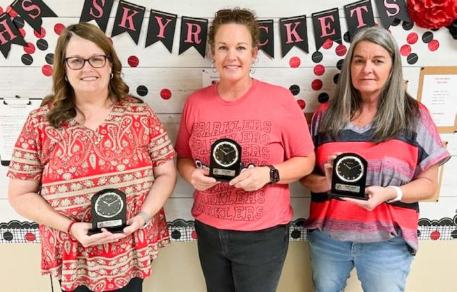 Karoline Ashmore, left, Carrie Skelton and Janelle Popwell mark 25 years of service to Wellington Independent School District with a desk clock memento.