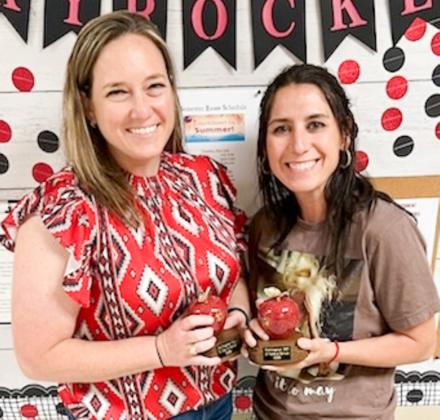 Awarded with red marble apples, Katie Page, left, and Ashly Cantu accept the gift for 10 years of service to Wellington Independent School District.