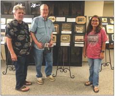 Scott Clark, left, and his dad, John Clark, a member of the Wellington High School Class of 1949, view Collingsworth County Museums “Once Upon Our Past” snapshot exhibit, which begins in 1898. Collingsworth County Museum Assistant Director Karen Caldwell welcomes the Clarks, both of Dewey, Ariz. Since 2019, the duo has enjoyed traveling back to Wellington to watch a Skyrocket football game. The Red River Sun/Bev Odom