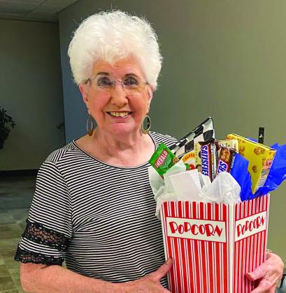 At the end of the evening, Glenna Fourmentin claims the movie night gift bucket by tallying the most bunco game wins during the Thursday, July 13 competition at Wellington Senior Citizen Center. Players warmed up with a round of practice bunco prior to the meal being served.
