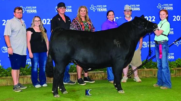 Wellington Junior High School eighth-grader Bailey Page shows the second-place Heavyweight Black Cross and made the sale with her steer, Roger, at the recent State Fair of Texas in Dallas. From left: Trevor Rosso, Hannah Worlein, Conner Cross, Brittni Cross, Katie Page, Jeremy Page, Bailey Page.