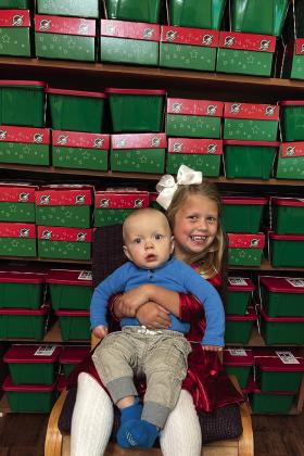 Lennox and Kellyn Conner, children of Tucker and Jordan Conner, complement the 117 Christmas shoeboxes, assembled by First Baptist Church Wellington, for Samaritan’s Purse Operation Christmas Child to be shipped to children in need around the world. The Red River Sun/Bev Odom