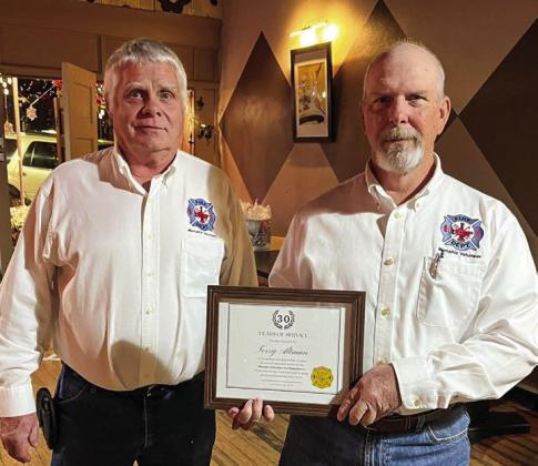 Memphis Volunteer Firefighter Terry Altman receives a 30-year service award, presented by Memphis Volunteer Firefighter Terry Altman.