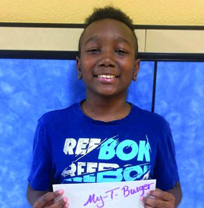Fourth-grader Braylen Coffee accepts the My-TBurger gift certificate on behalf of his mother, Cassandra Coffee.