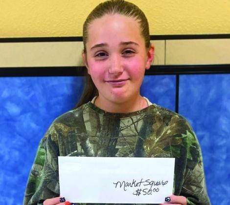 Fifth-grader Dixie Thomas accepts the Market Square Supermarkets gift card on behalf of her mother, Jessica Thomas.
