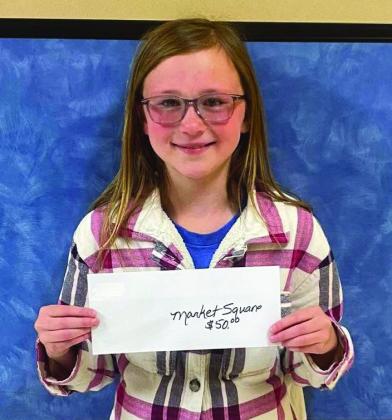 Third-grader Kaizley Byers accepts the Market Square Supermarkets gift card on behalf of her dad, Chance Byers. Wellington Elementary School