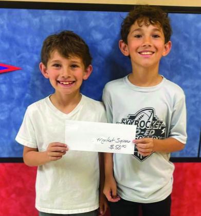 Third-grader Noah Peters, left, and fifthgrader David Peters accept the Market Square Supermarkets gift card on behalf of their mother, Marci Peters. Wellington Elementary School