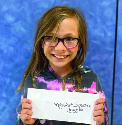 Fifth-grader Audrey Cummings accepts the Market Square Supermarkets gift card on behalf of her dad, Logan Cummings.