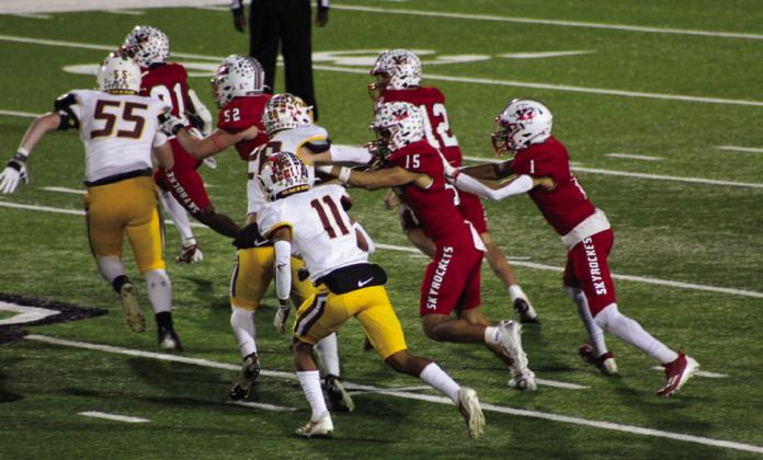 Travon Lewis (21) totes the ball for Wellington, backed by Hunter Hedrick (52), Callen Kane (12), Anthony Ortiz (15) and Brenden Garcia (1), Friday, Nov. 22 at Hawk Stadium in Iowa Park. The Skyrockets ended the season with an overall record of 9-3.
