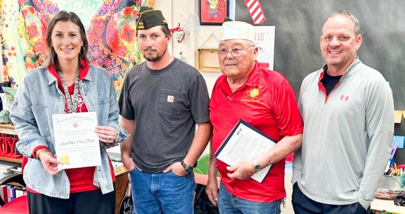 Wellington Junior High School (WJHS) educator Heather Proffitt accepts the Smart/Maher Veterans of Foreign Wars (VFW) National Citizenship Education Teacher Award, presented by Glynn Moore VFW Post 6439 Senior Vice Commander Johnny Davis and Quartermaster Jr. Castillo. WJHS Principal Shannon Fisher applauds Proffitt. From left: Proffitt, Davis, Castillo, Fisher.