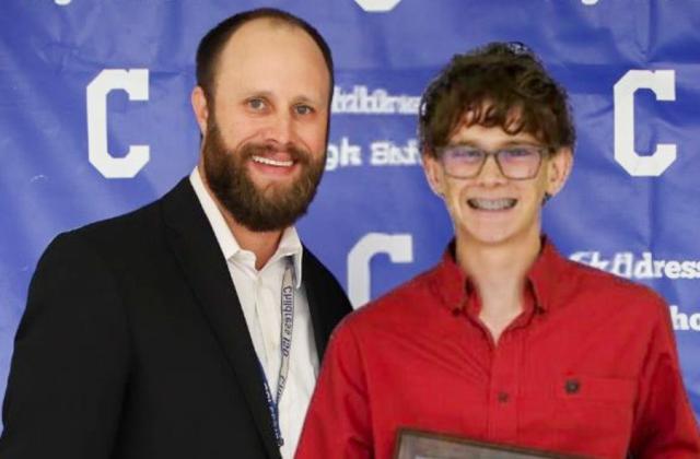 Hudson Elliott receives the Bobcat Cross County Most Valuable Player Award, presented by Athletic Director Bo Helm.