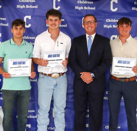 Dylan Moore, Crewz Keys and Noah Ellerbrook receiving the Bobcat Basketball Fighting Heart Award, presented by Bobcat Head Basketball Coach Colby Schneiderjan.