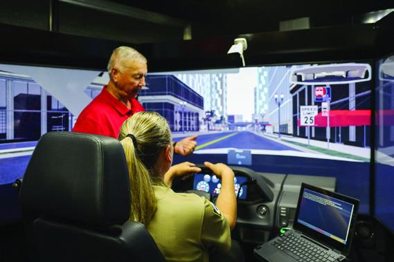 Childress County Sheriff’s Office Secretary Kari Bailey is instructed by Texas Association of Counties Driving Simulator Consultant II Don Courtney in September. Through the Lens of Liz