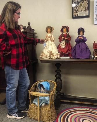 Collingsworth County Museum Curator Karen Caldwell highlights the doll collection made by the late Inez and Mabel Clement, which used real hair from family members. The late Lora Mae Sexton, Judy Wischkaemper’s mother, gave the late Ruth Caldwell, Karen’s mom, the doll, sitting on the antique multi-use child’s chair, near her feet.