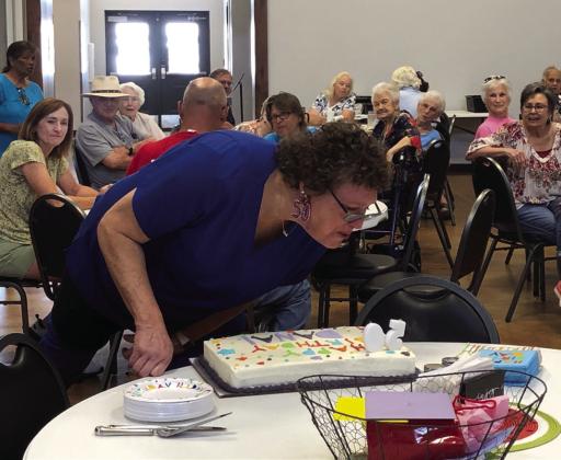 Decked out in her “50” earrings, Dana Langford Hughs blows out her candles at a surprise birthday party in her honor at 12:30 p.m. Monday, July 17 at Wellington Senior Citizens Center, where Hughs serves as kitchen manager. The Red River Sun/Bev Odom
