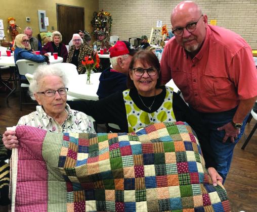 Odessa Covey, with Gwynna “Gigi” and Cliff Waller, admire the quilt Covey constructed and hand quilted. The Wallers purchased the quilt during the Nov. 5 Methodist Women’s Fall Bazaar. Attendees enjoyed the stew and chili lunch with dessert and a drink served from 11 a.m. to 1 p.m. The Red River Sun/Bev Odom