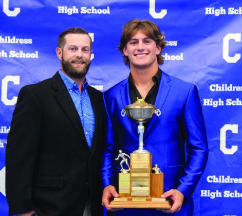 Scout Smith, right, accepts the Jackie Smith Outstanding Defensive Most Valuable Player award from Defensive Coordinator Matthew Olson.