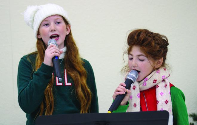 Monson Music Studio students Liesel Schaefer and Bella Blu Sanders sing carols during Christmas In The Park’s Lighting of the Park festivities Saturday, Nov. 25 at Fair Park City Auditorium.