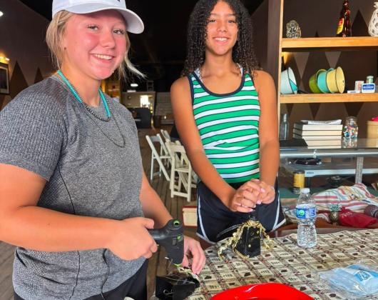 Cyclone fans decorate their cow bells during a recent booster club activity.